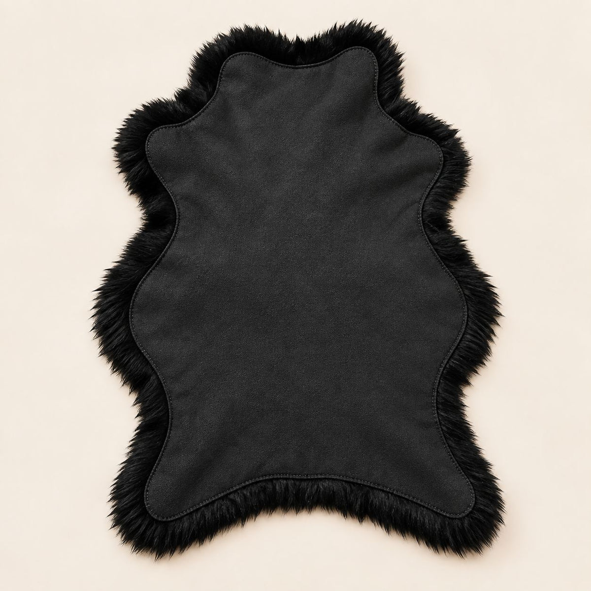Reverse side of black fur floor mat showing lambskin suede backing