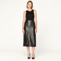 Woman wearing black A-line high-waisted leather midi skirt, front view